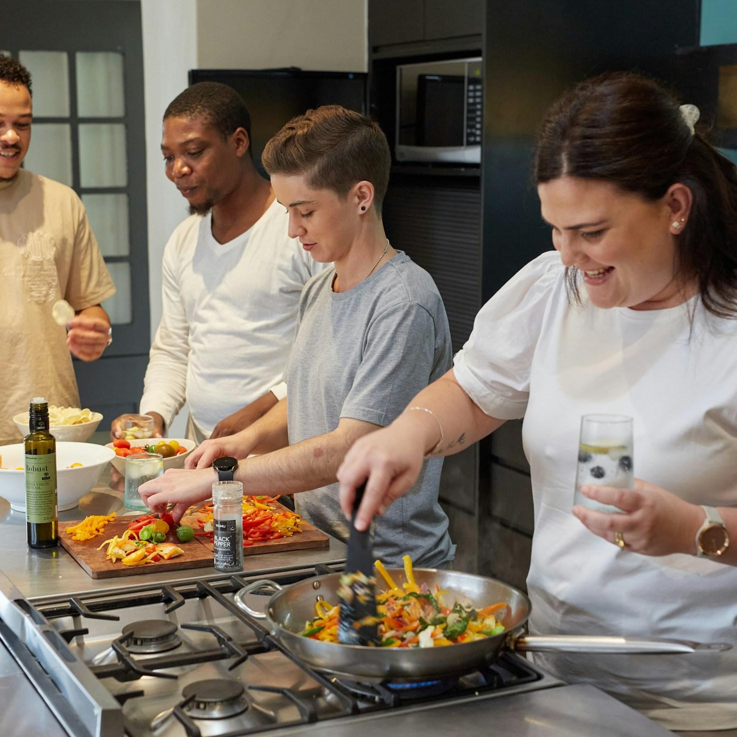 Community members collaborating in a modern kitchen space, sharing recipes and cooking techniques